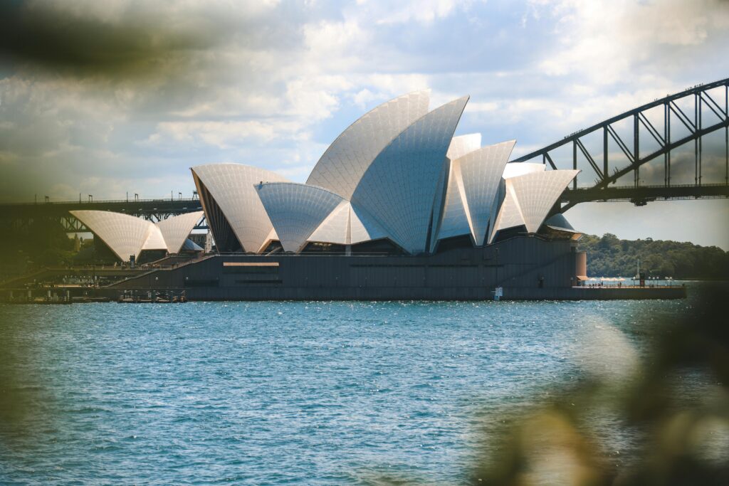 Iconic view of the Sydney Opera House and Sydney Harbor Bridge on a sunny day.